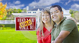 Couple in Front of Sold Real Estate Sign and House