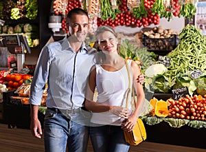 Couple in front of vegetable shop counter photo