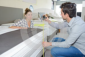 Couple in furniture store measuring bed