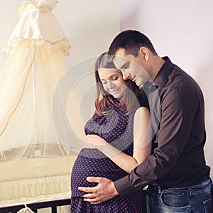 Couple future parents near a cot.