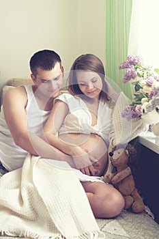 Couple future parents relaxing on a sofa.