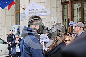 Couple with gas masks in protest for extreme air pollution, in front of the Ministry of Environment building, in Bucharest