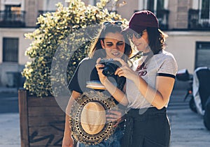 A couple of gay woman sightseeing together, smiling and looking his reflex photo camera. Same sex young married female couple