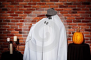 Couple of ghosts posing over brick background. Halloween party.