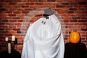 Couple of ghosts posing over brick background. Halloween party.