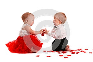 Couple girl and boy babies playing with hearts concept valentine