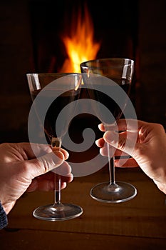 Couple With Glass Of Wine Relaxing By Fire