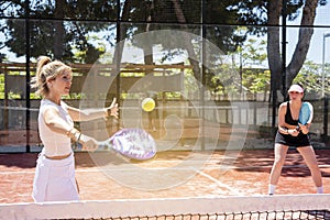 Couple go to net to attck action in paddle tennis match in outdoor