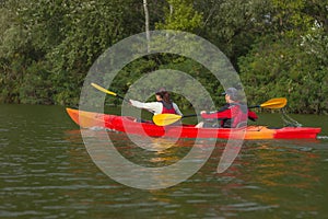 The couple goes kayaking on the river.