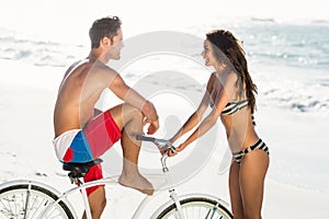 Couple going on a bike ride on the beach