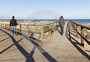 Couple going by different path on a wooden walkway in Arenales d photo