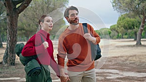 Couple going hike nature with backpacks. Happy family walking on autumn forest.