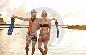 Couple is going to swim and snorkle on hawaii beach at the sunset