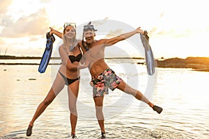 Couple is going to swim and snorkle on hawaii beach at the sunset