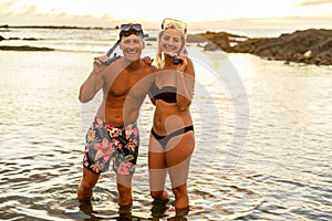 Couple is going to swim and snorkle on hawaii beach at the sunset