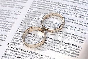 Couple of gold wedding rings on a dictionary page