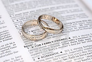 Couple of gold wedding rings on a dictionary page