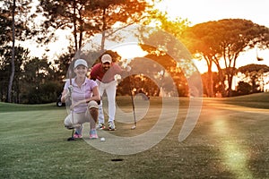 Couple on golf course at sunset