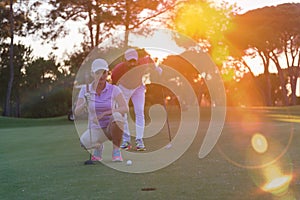 Couple on golf course at sunset