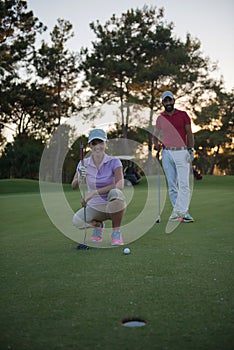 Couple on golf course at sunset