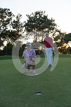 Couple on golf course at sunset