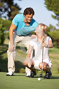 Couple Golfing On Golf Course