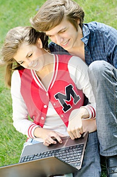 Couple in the grass with computer
