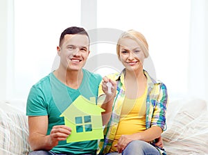 Couple with green house and keys in new home