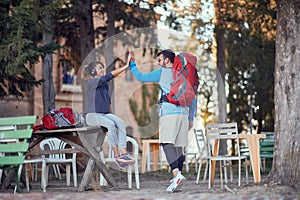 Couple greeting each other with high five at hiking