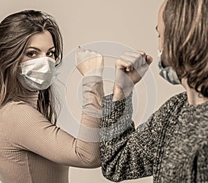 Couple greeting with elbows. Friends in protective medical mask on his face greet their elbows in quarantine. Elbow bump