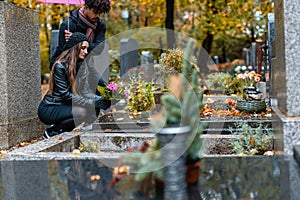 Couple in grief on a cemetery in fall