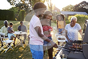Couple grilling at a black multi generation family barbecue