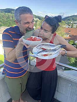 Couple grilling fish and vegetables