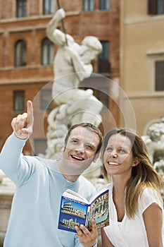 Couple With Guidebook Looking At Monuments