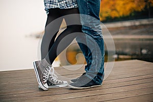 Couple in gumshoes kissing on the river dock