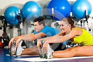Couple in gym stretching photo