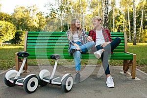 Couple with gyroboard sitting on the bench in park