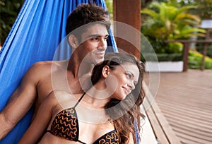 Couple, hammock rest at holiday resort for summer vacation in Hawaii for honeymoon, bonding or stress relief. Man, woman