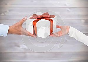 Couple hands holding gift against blur wooden background