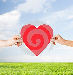 Couple hands holding red heart