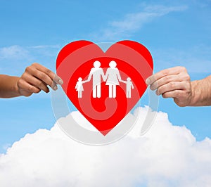 Couple hands holding red heart with family