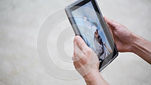 Couple hands with tablet pc viewing photos at home
