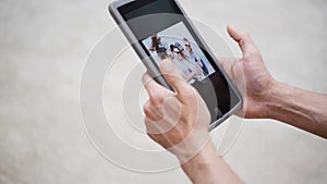 Couple hands with tablet pc viewing photos at home