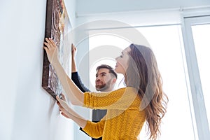 Couple hanging picture on the wall