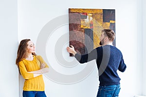 Couple hanging picture on the wall