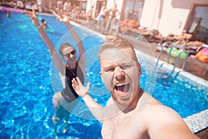 Couple happy caucasian beautiful young woman and man make selfie photo on background swimming pool. Concept travel