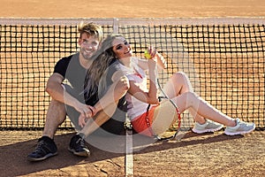 couple. Happy couple in love sit at tennis net on court