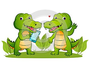 The couple of happy crocodile is holding a smart phone