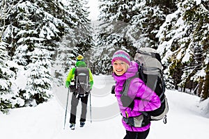 Couple happy hikers trekking in winter woods