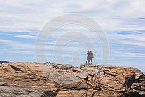 Couple of happy hispanics people standing backs on top of cliff and overlooking stunning view to Atlantic ocean photo